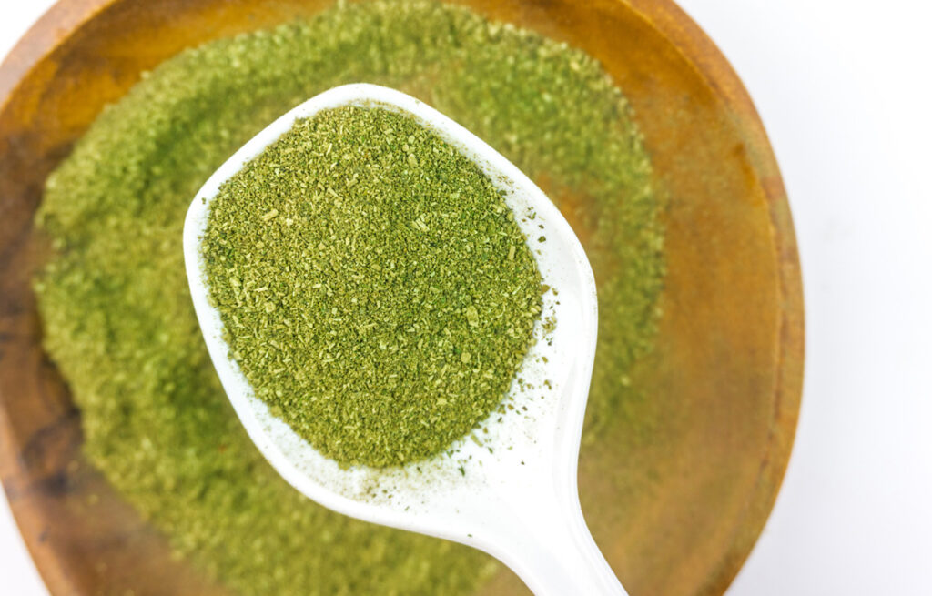 A close-up of kratom powder in a spoon highlights its natural form, focusing on kratom benefits and what does kratom feel like